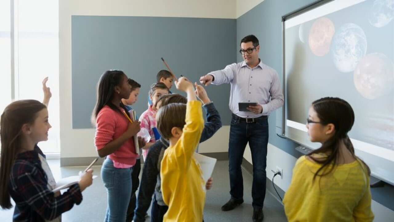 Students asking questions of teacher leading astronomy lesson