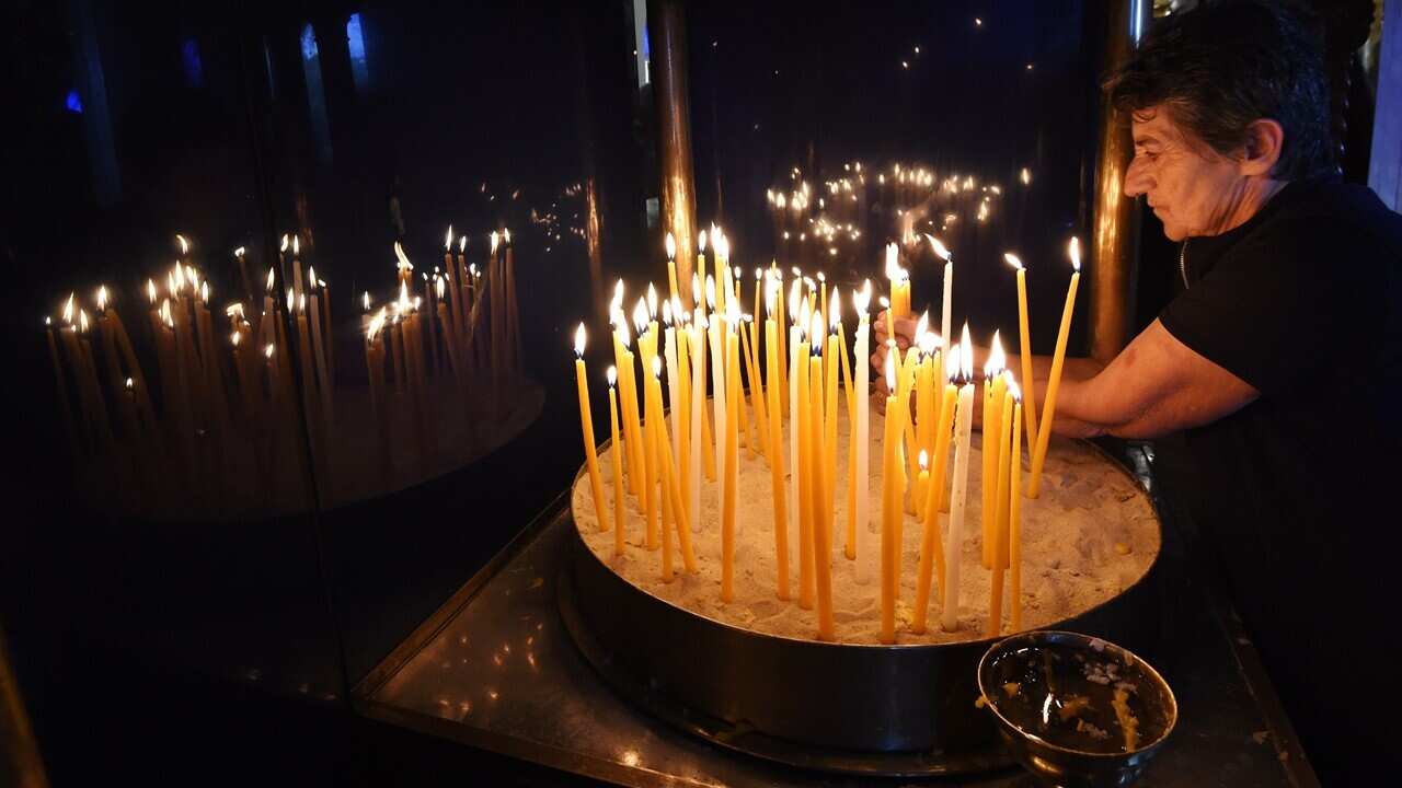 A parishioner lights a candle during an Easter service. 