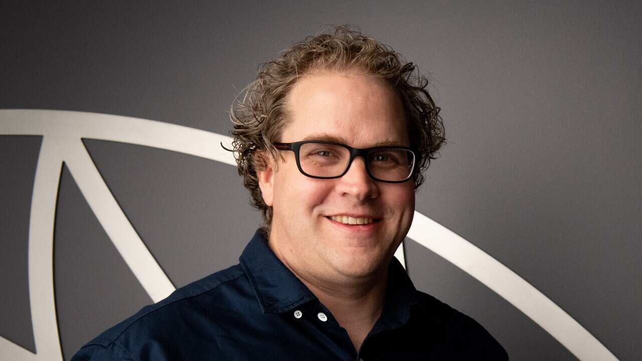 Headshot of Sam Ringwaldt in a navy business shirt.