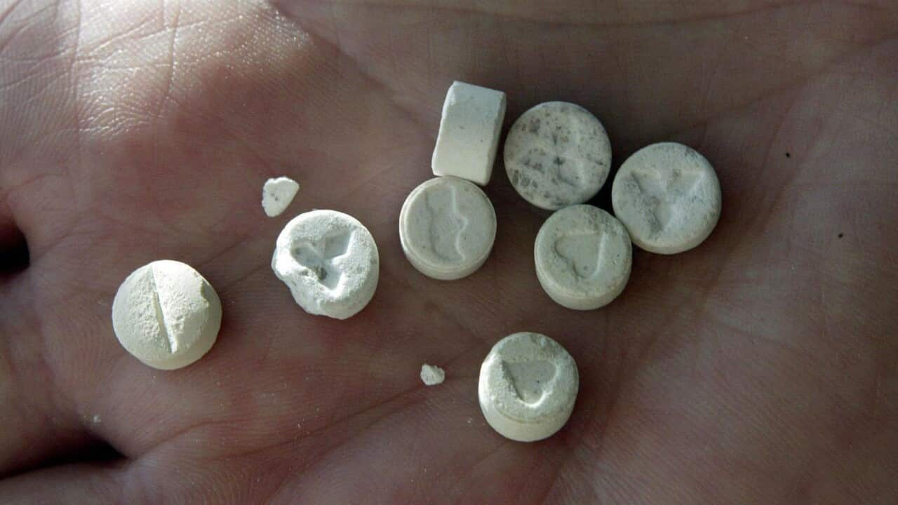 File photo of a person holding MDMA tablets.