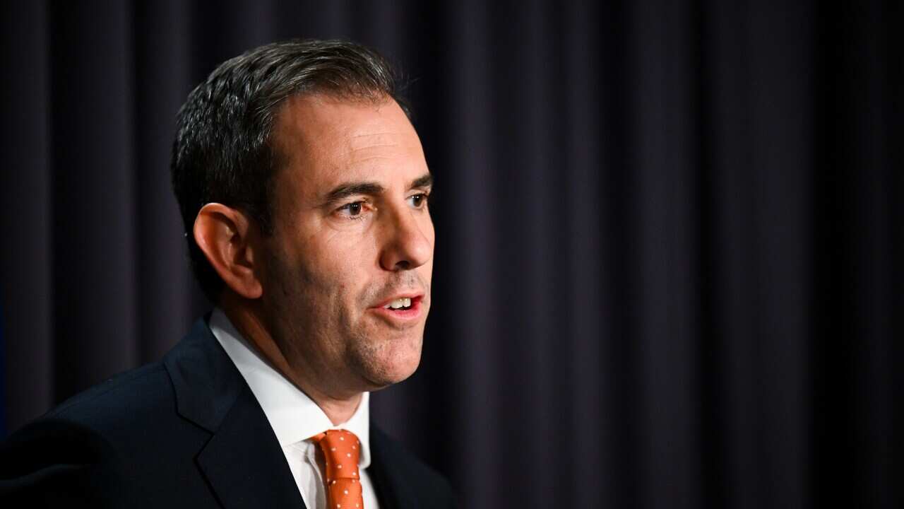 A man with a suit and tie speaks at a press conference.