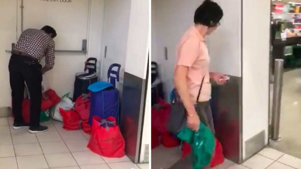 A man fills bags with baby formula while a woman returns to the store.