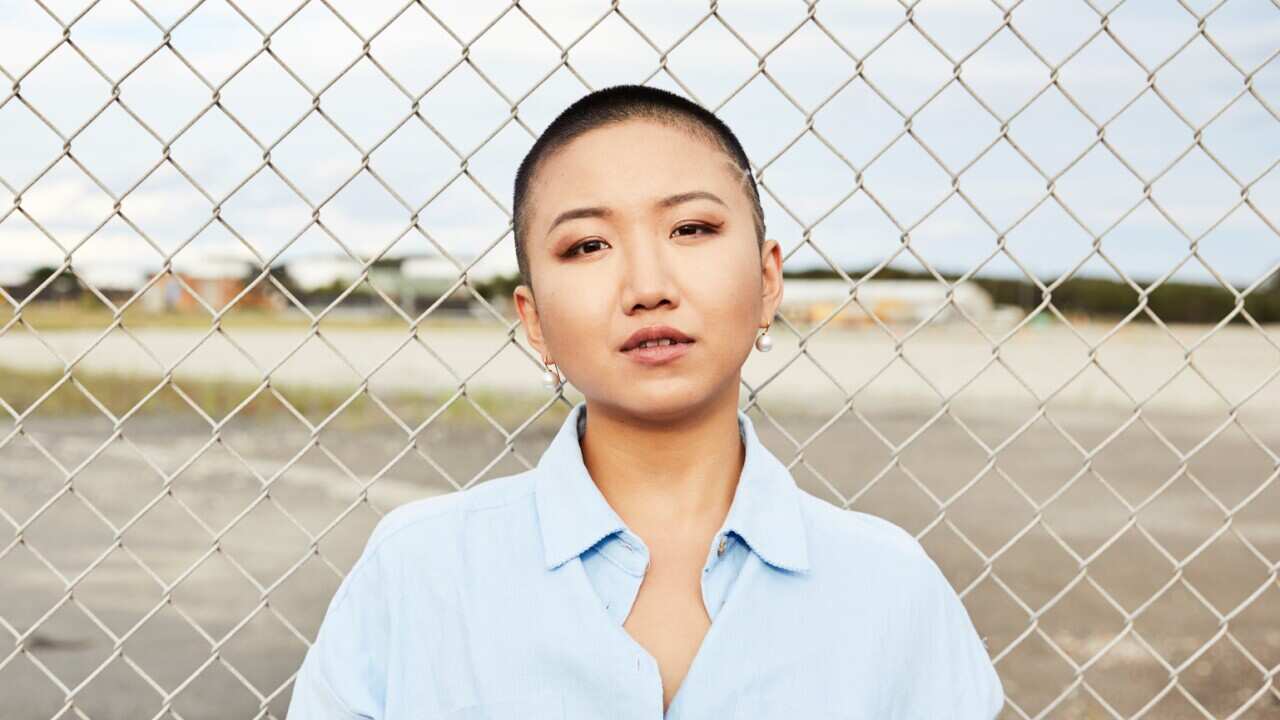 Vicky Xu in front of wire fence.