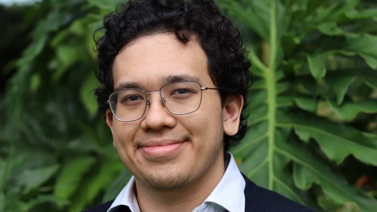 Retrato de un hombre con gafas y sudadera azul