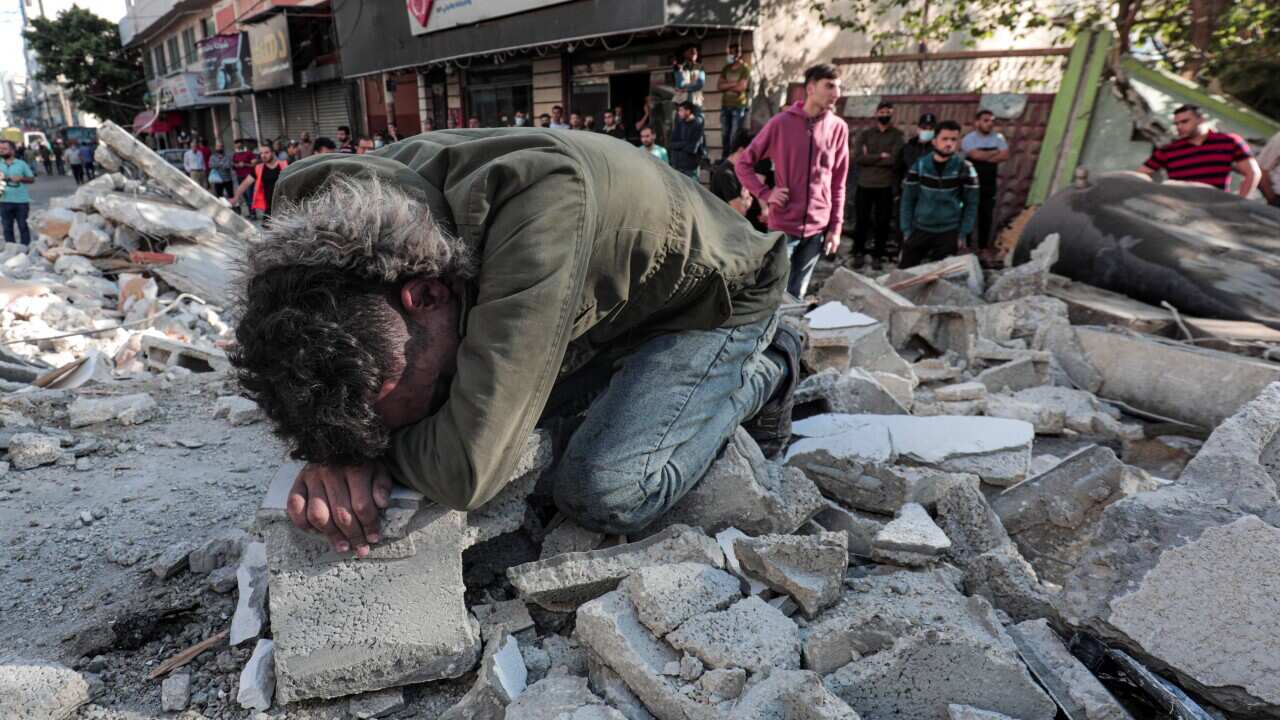 Palestinians evacuate children, women, and the elderly from under the rubble of their destroyed home after an Israeli air raid on Gaza City, on 16 May.