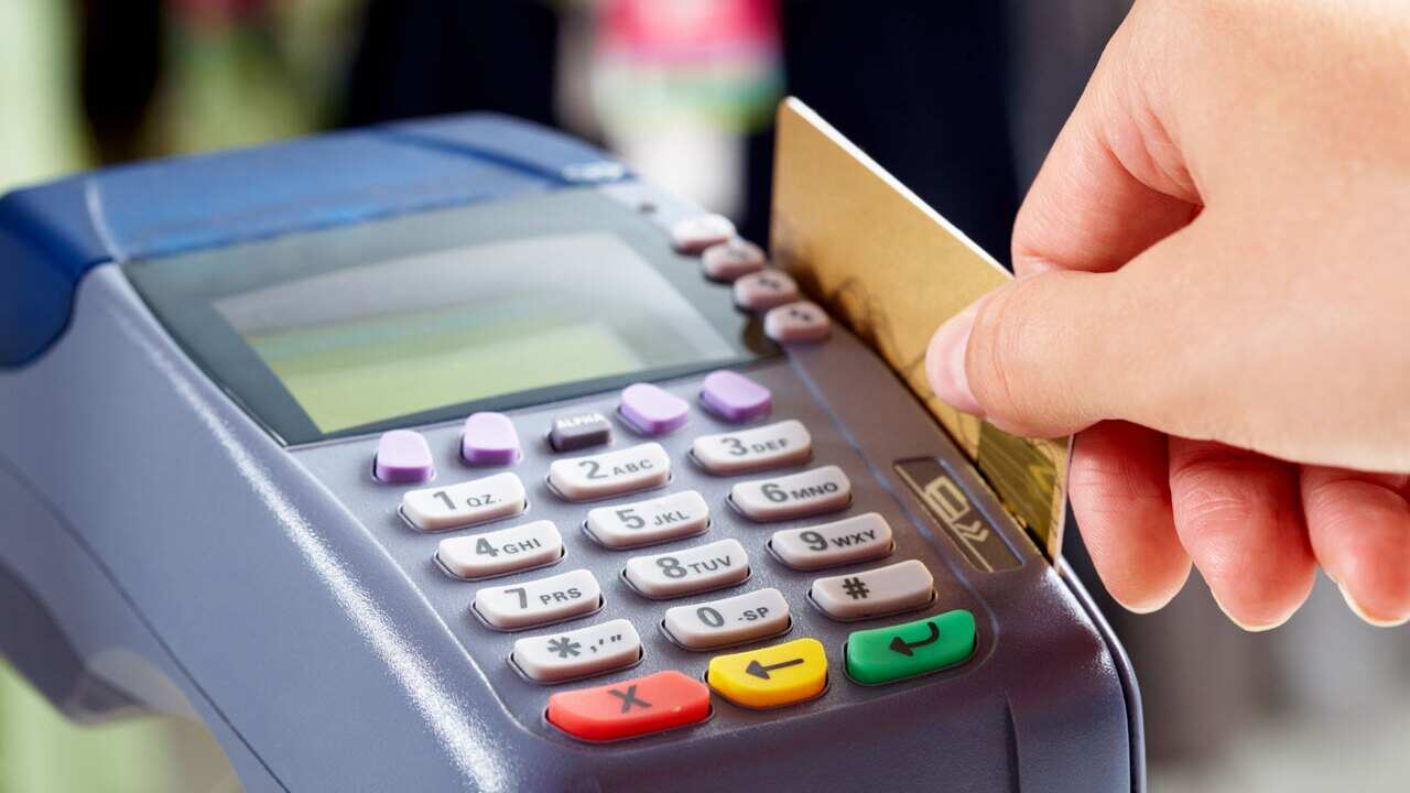 A debit card being swiped through an EFTPOS machine in Canberra