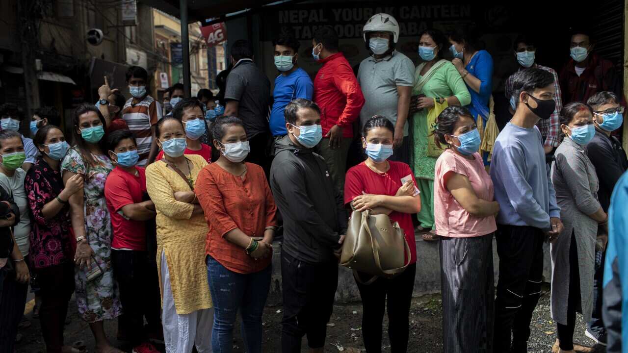 A group of women line up to receive a dose of Shinopharm Vero cell COVID-19 vaccine in Kathmandu, Nepal. 31 July 2021.