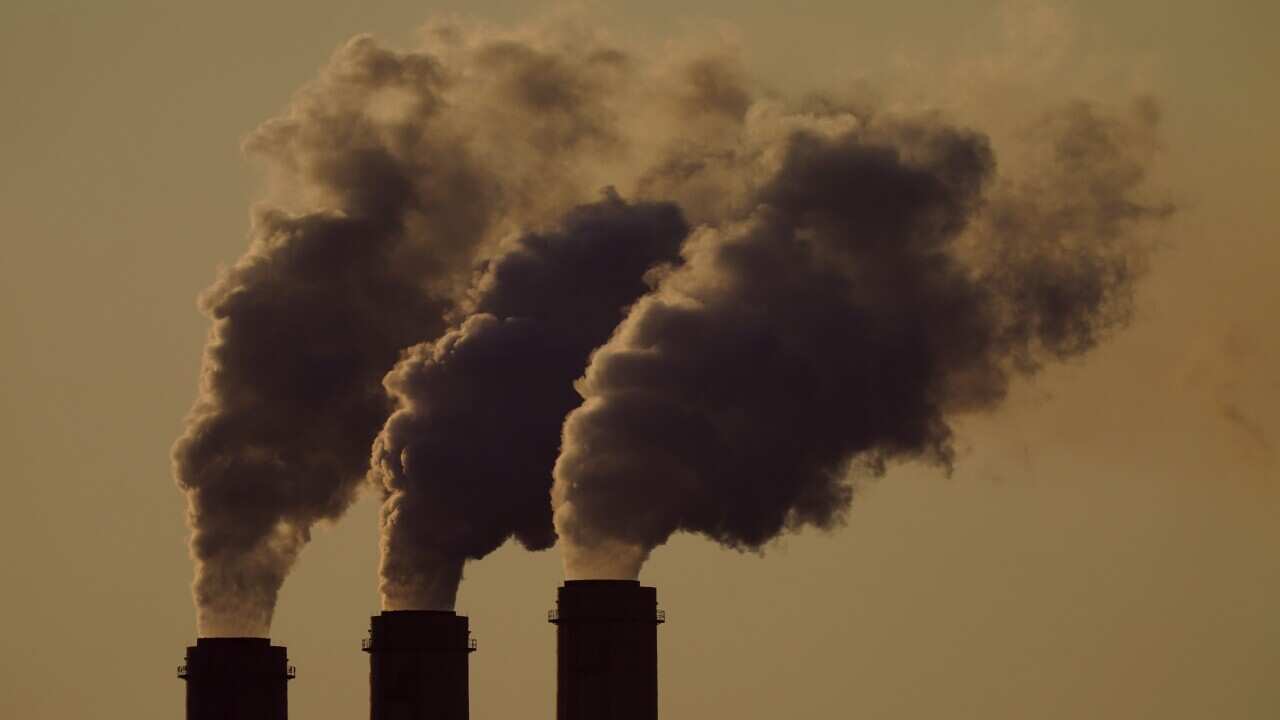 Emissions from the smokestacks at the Jeffrey Energy Center coal power plant as the suns sets, near Emmett, Kansas, United States.  