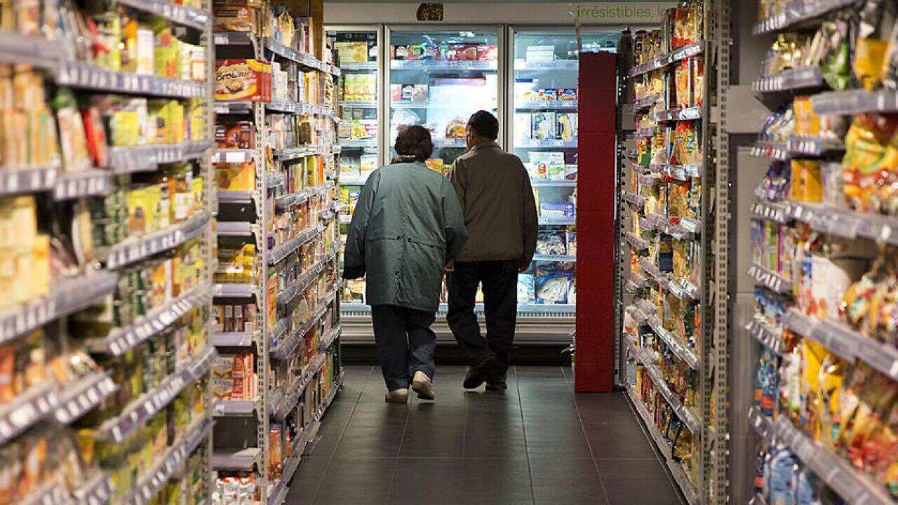 Two people in a supermarket aisle. 