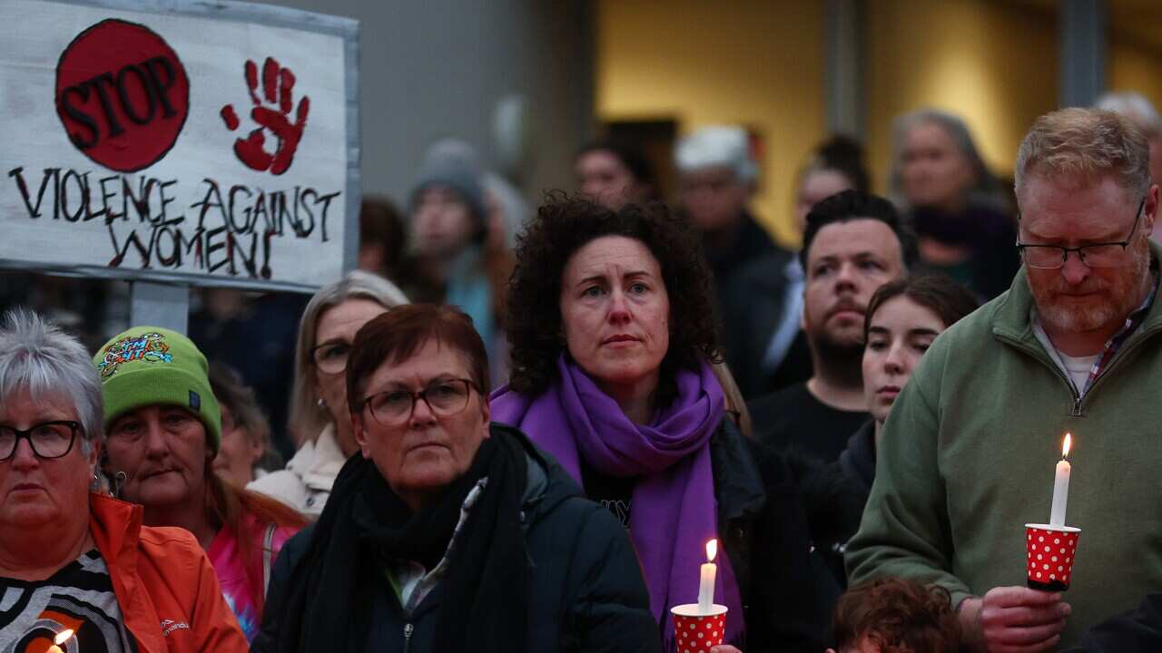 A group of protesters, some holding candles.