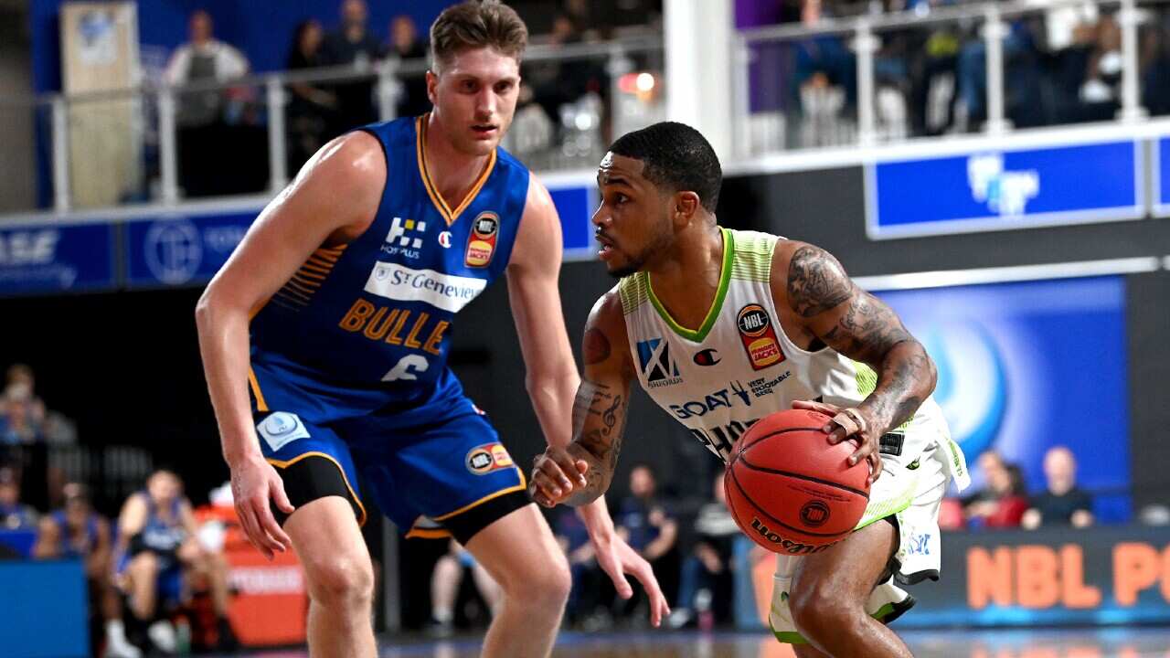 South East Melbourne Phoenix star Keifer Sykes attempts to dribble past Matt Hodgson of the Brisbane Bullets