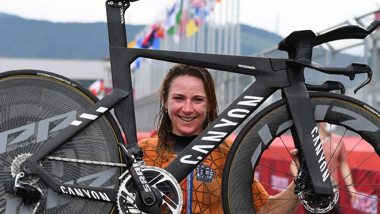 Annemiek van Vleuten hoists her bike in celebration of Olympic time trial gold