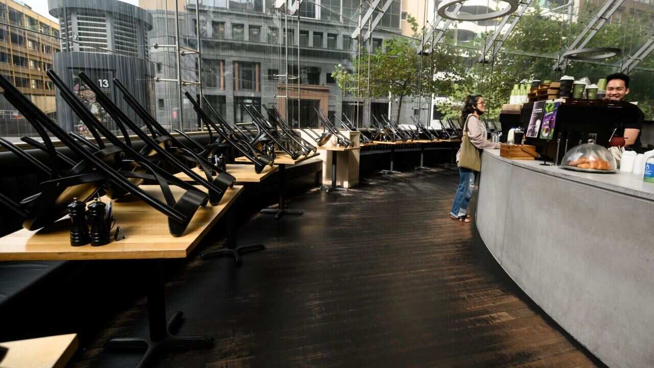 A person orders at a cafe which has closed its indoor seating area and switched to takeaway only