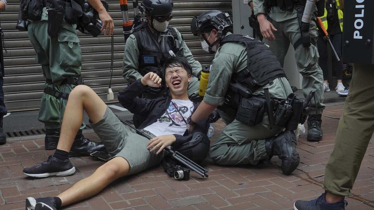 A reporter falls after being sprayed with pepper spray by police on 1 July, 2020.  