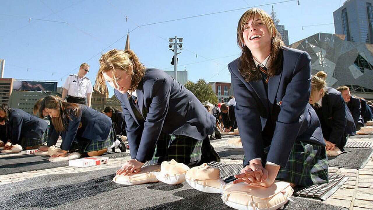 School girls practicing life saving CPR Skill