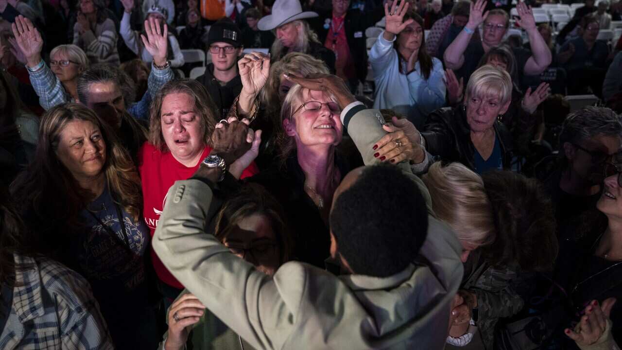 Attendees are prayed over during a worship and prayer time at the ReAwaken America Tour