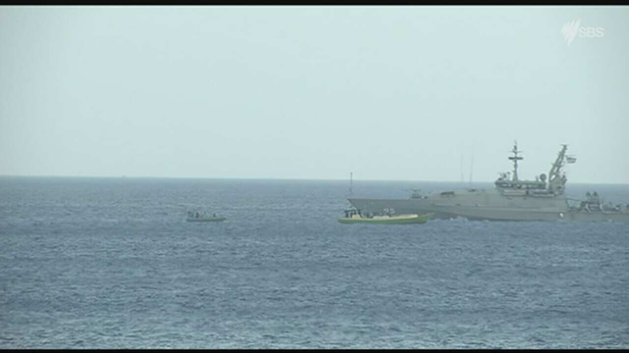 SBS correspondent Ryan Emery is on the island and captured the moment the Australian navy turned the boat around just off the island’s coast and accompanied it back out to sea. (SBS/Ryan Emery)