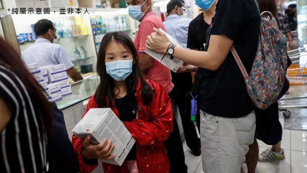 A young girl holds a box of N95 masks at a shopping mall in Singapore