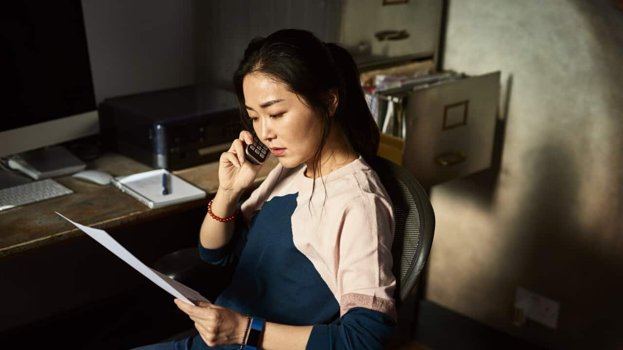 Portrait of Korean woman on cell phone reading important document