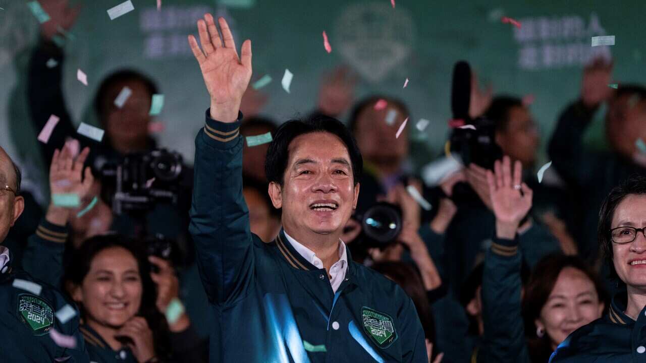 A man waves with colourful paper confetti raining down on him.