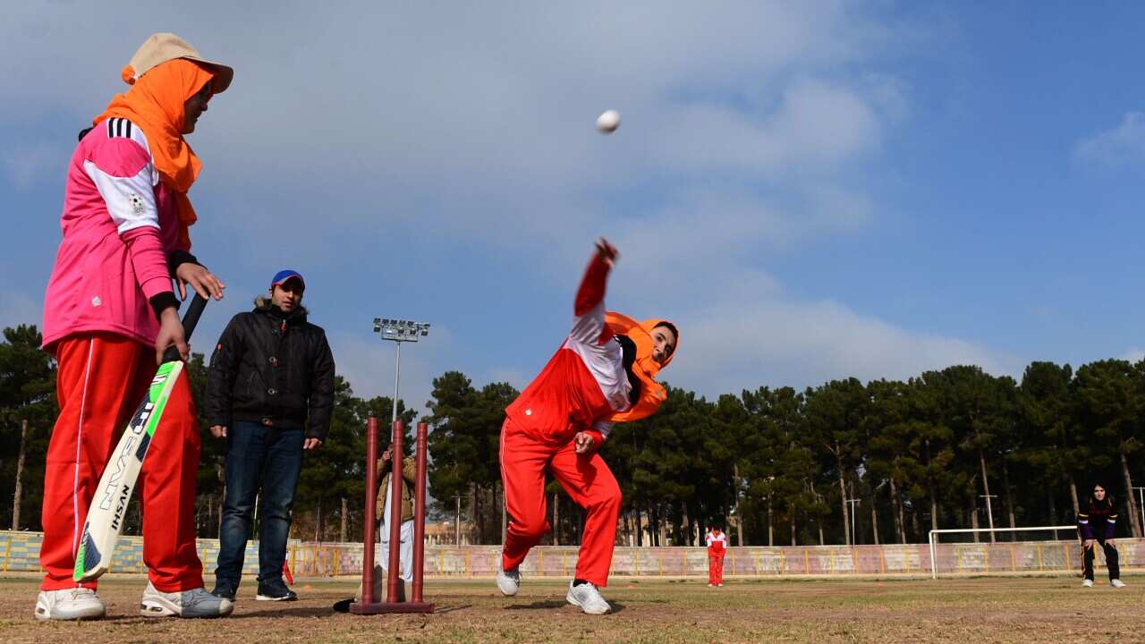 Afghan women play cricket at the grounds of the stadium in Herat on December 9, 2015.