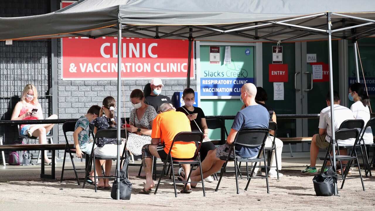 People wait outside a COVID testing clinic South of Brisbane, Wednesday, January 5, 2022. (AAP Image/Jono Searle) NO ARCHIVING