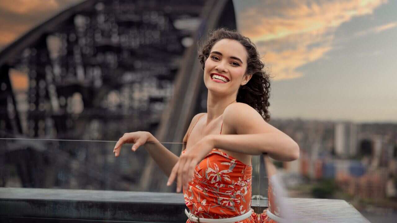 Nina Korbe on top of Harbour Bridge smiling at the camera. 