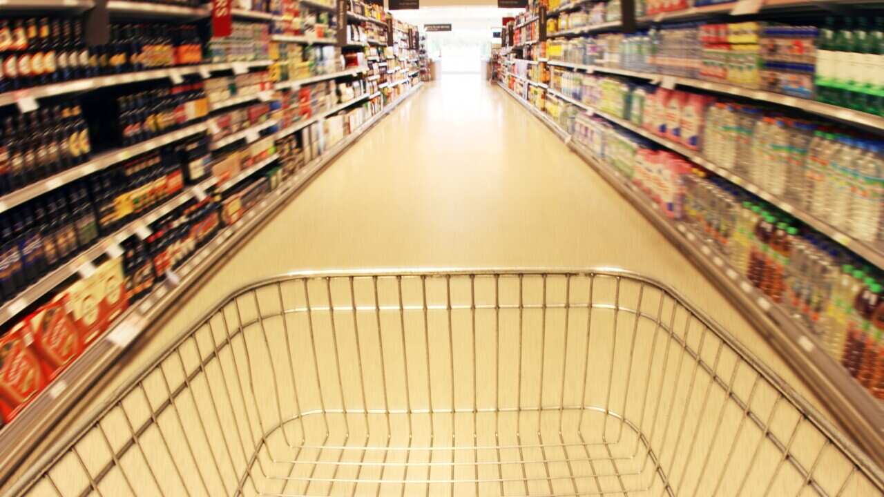 Trolley in supermarket aisle and shopping