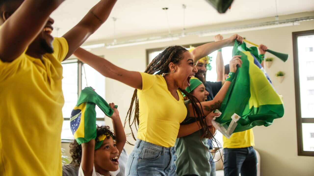 Soccer fans cheering at home.