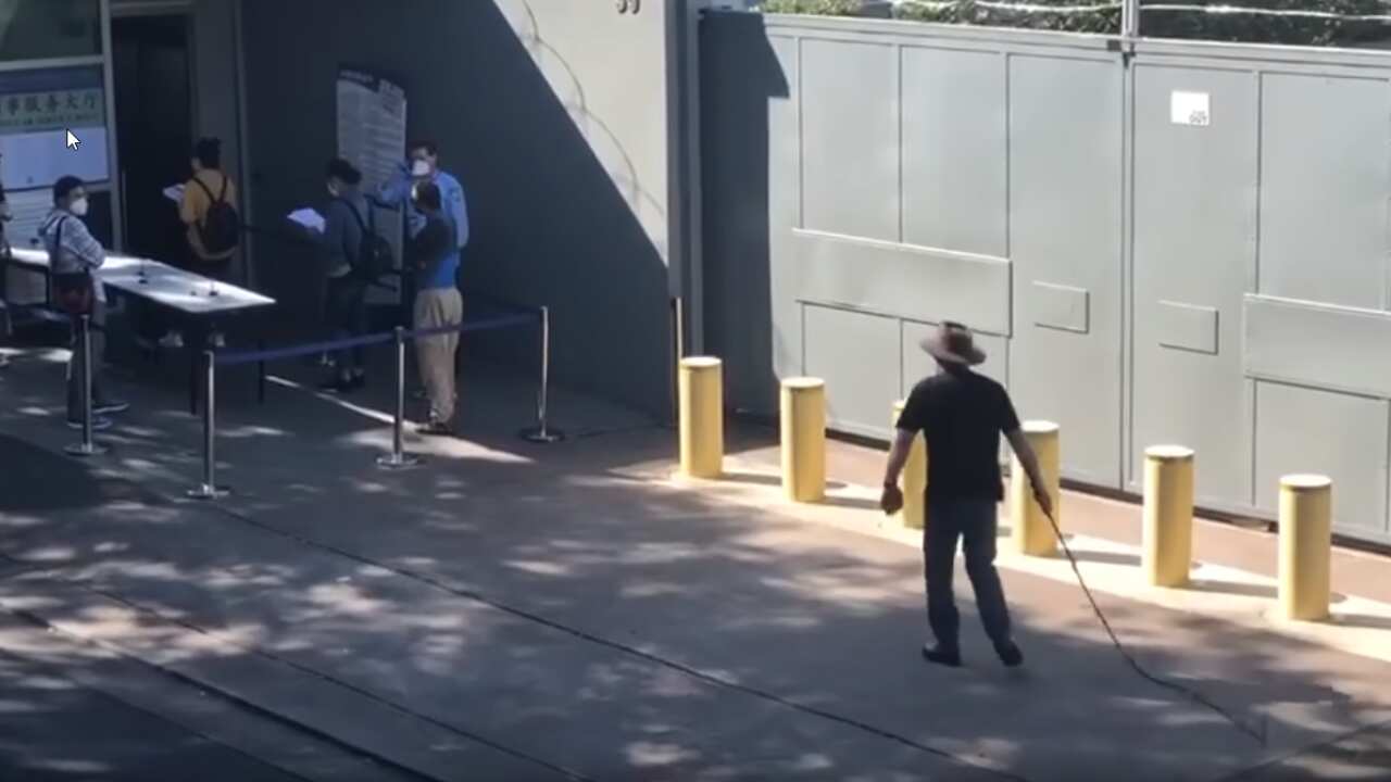 A man wearing an Akubra and brandishing a whip allegedly threatened people outside the Chinese consulate in Sydney.