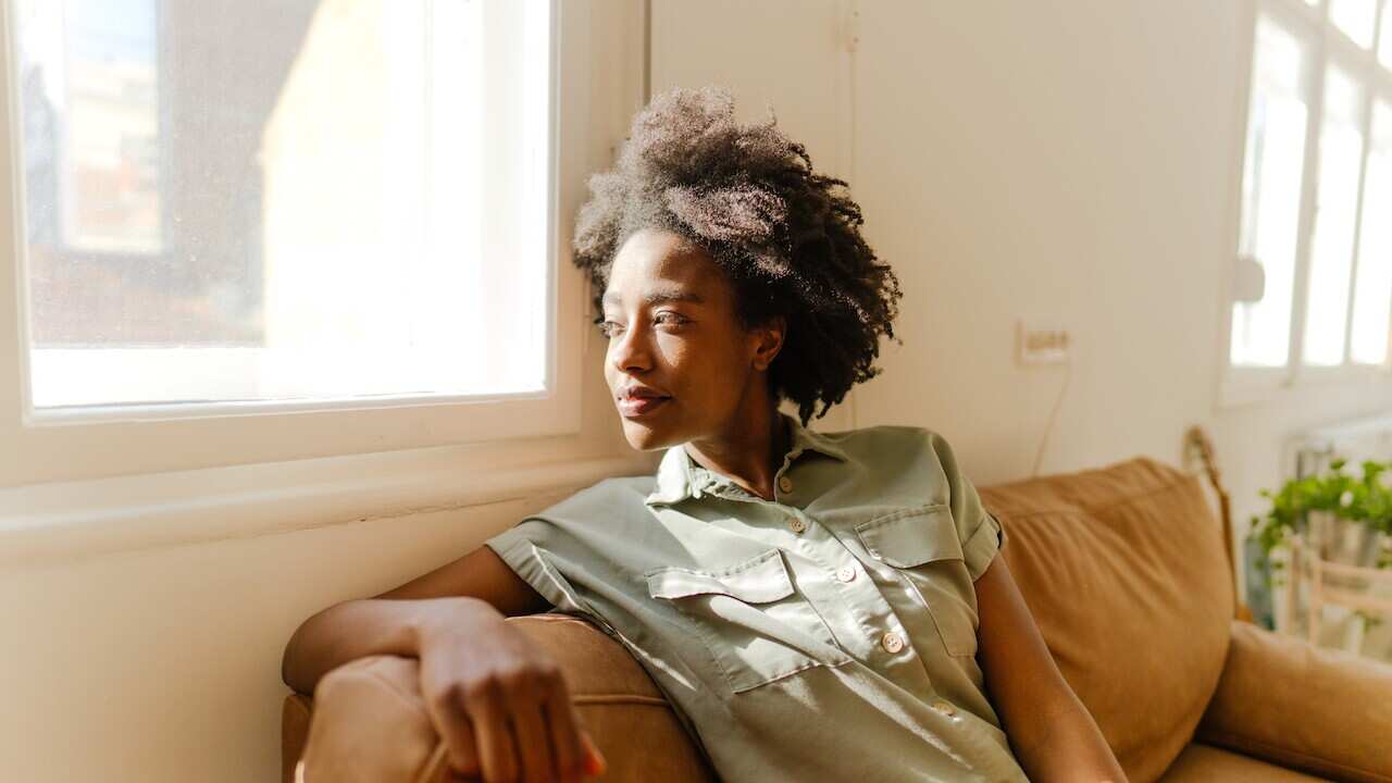 Young woman enjoying rays of sunshine in her living room